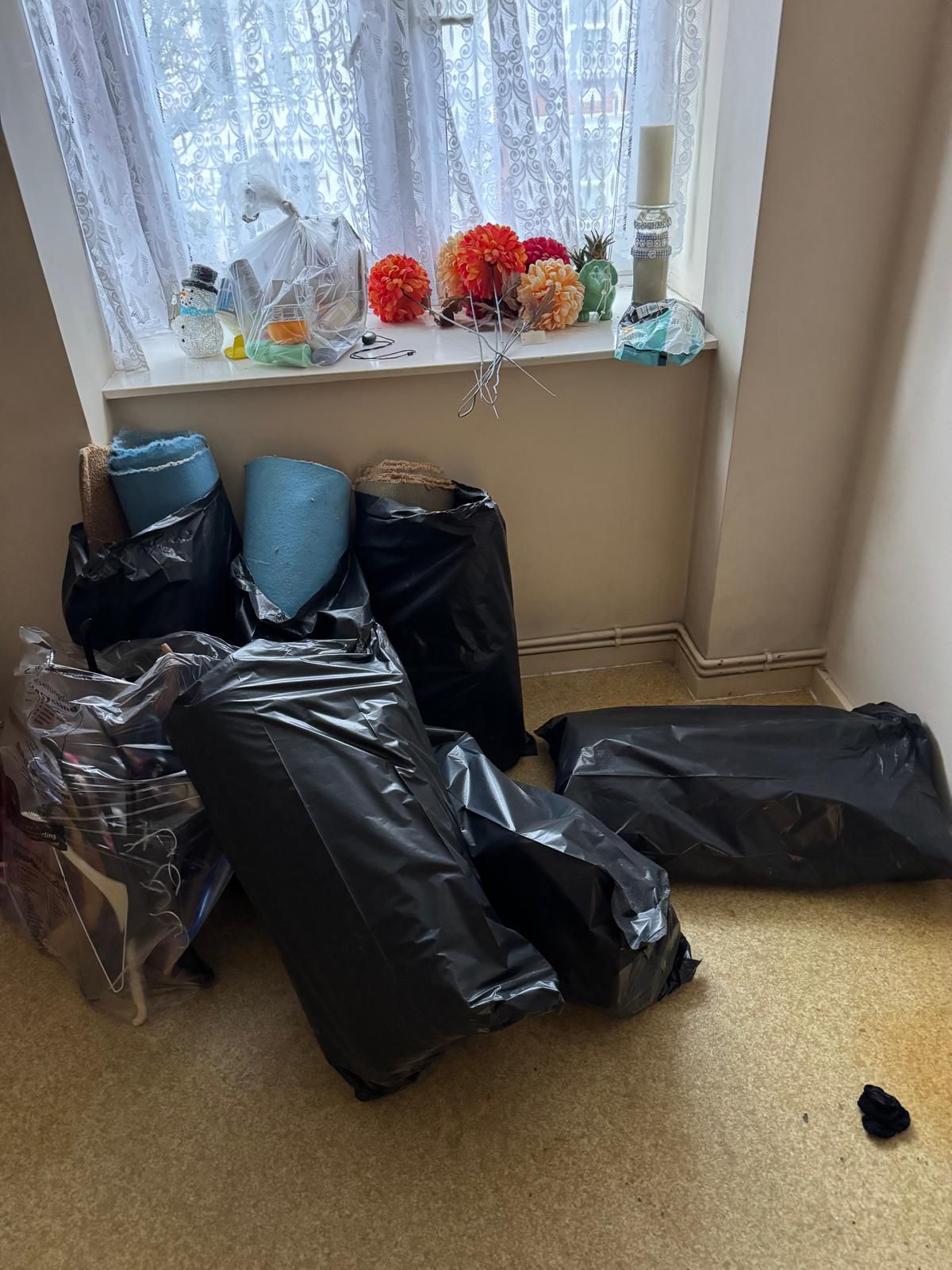 Room before clearance — filled with rubbish bags and clutter